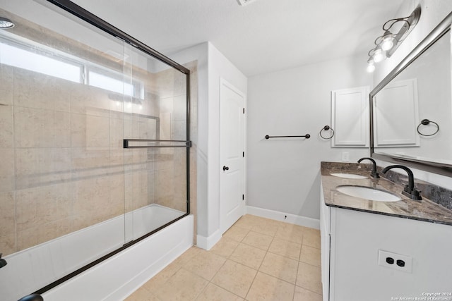 bathroom featuring tile patterned flooring, vanity, and bath / shower combo with glass door