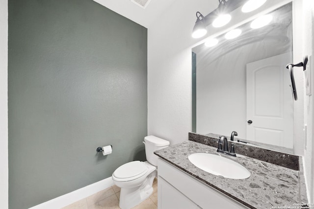 bathroom with tile patterned flooring, vanity, and toilet