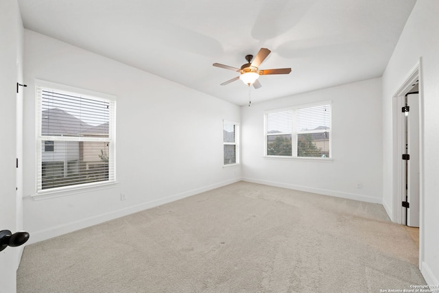 spare room with ceiling fan and light colored carpet