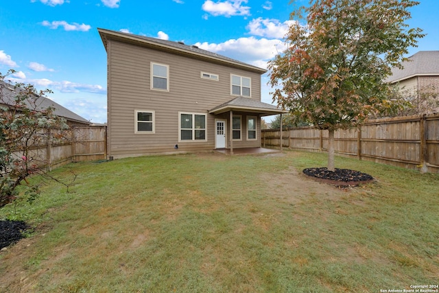 back of house with a yard and a patio area