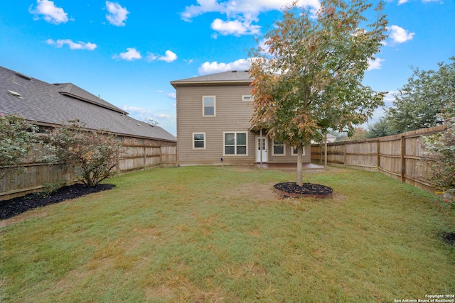 rear view of house featuring a yard