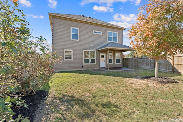 back of house featuring a patio area and a lawn