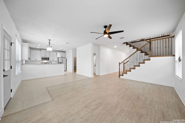 unfurnished living room featuring light hardwood / wood-style floors and ceiling fan