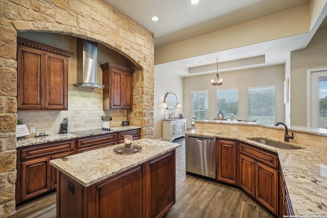 kitchen featuring black electric stovetop, wall chimney range hood, decorative light fixtures, dishwasher, and dark hardwood / wood-style floors