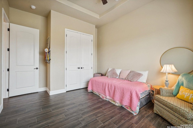 bedroom with dark hardwood / wood-style floors, ceiling fan, and a closet