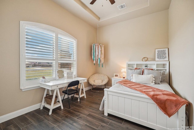 bedroom featuring a tray ceiling, ceiling fan, and dark hardwood / wood-style floors