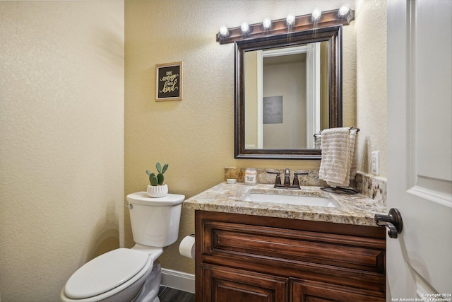 bathroom with hardwood / wood-style floors, vanity, and toilet