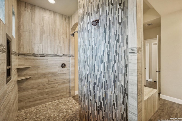 bathroom featuring a tile shower and hardwood / wood-style flooring