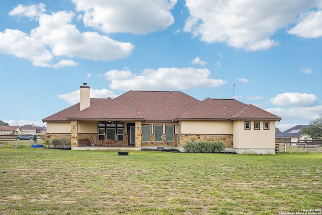 rear view of property featuring a yard