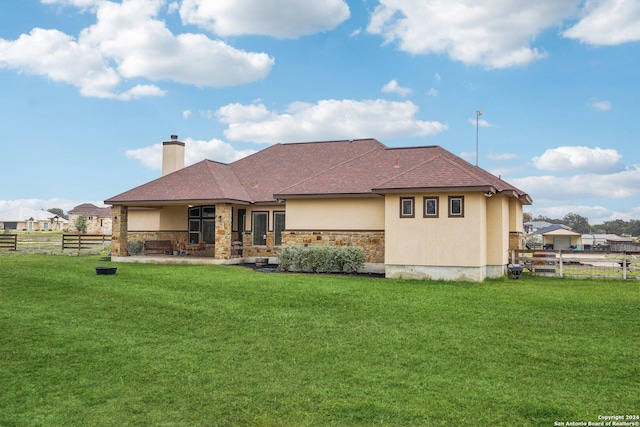 rear view of property featuring a yard