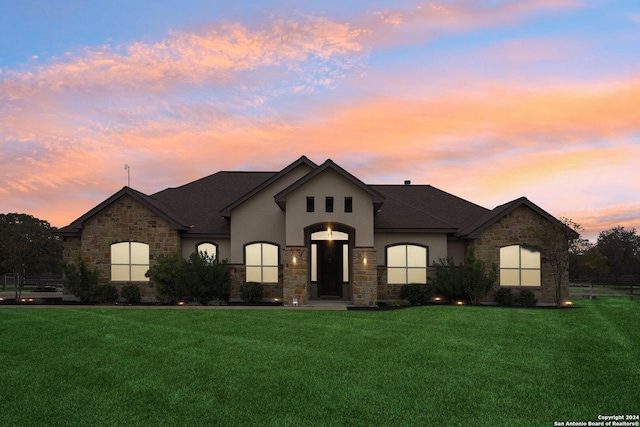 french country home featuring a lawn