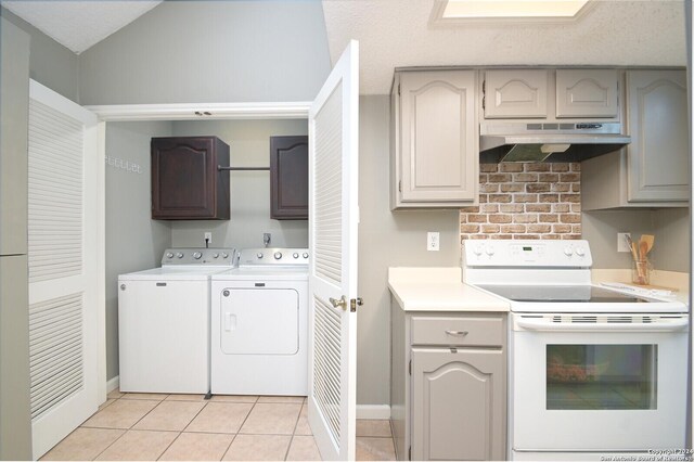 kitchen featuring washing machine and clothes dryer, light tile patterned floors, and electric stove