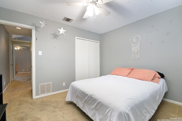 carpeted bedroom featuring ceiling fan and a closet