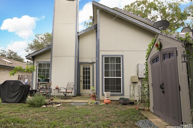 rear view of house with a storage unit