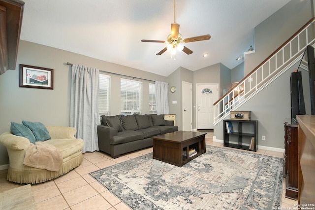 living room featuring ceiling fan, light tile patterned floors, and vaulted ceiling