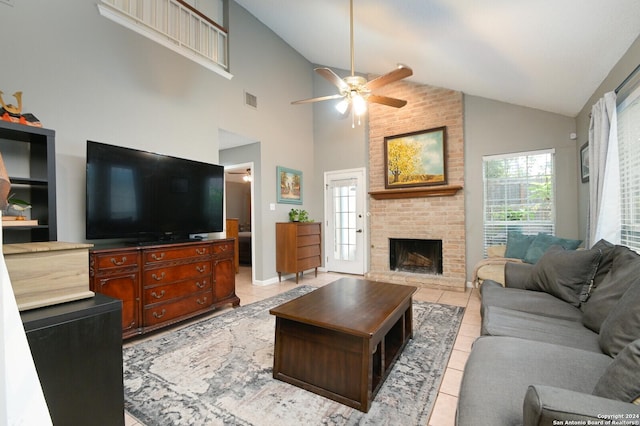 tiled living room with ceiling fan, a fireplace, and high vaulted ceiling