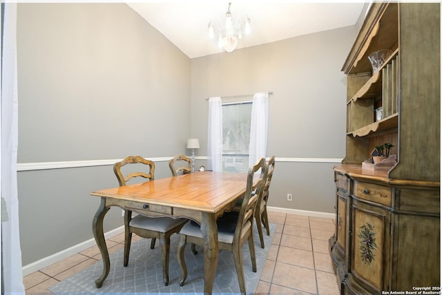 tiled dining room with a chandelier and vaulted ceiling