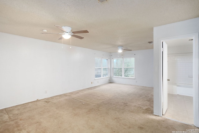 carpeted spare room with a textured ceiling and ceiling fan