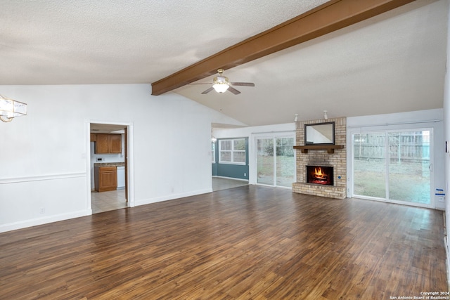 unfurnished living room featuring a textured ceiling, ceiling fan with notable chandelier, hardwood / wood-style flooring, a fireplace, and vaulted ceiling with beams