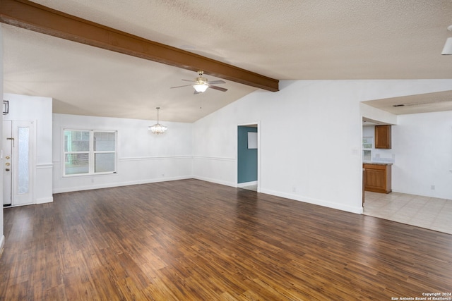 unfurnished living room featuring vaulted ceiling with beams, light hardwood / wood-style floors, a textured ceiling, and ceiling fan with notable chandelier