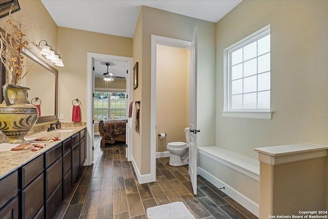 bathroom featuring ceiling fan, toilet, and vanity