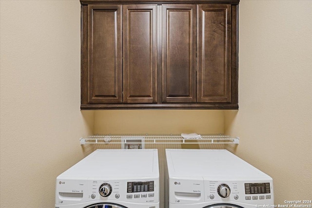 washroom featuring separate washer and dryer and cabinets