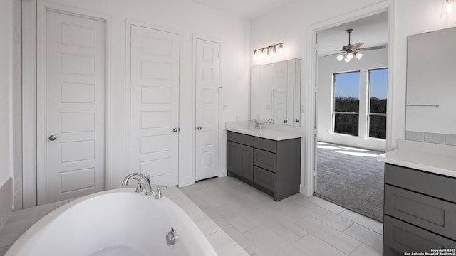 full bathroom featuring a freestanding tub, a ceiling fan, and vanity