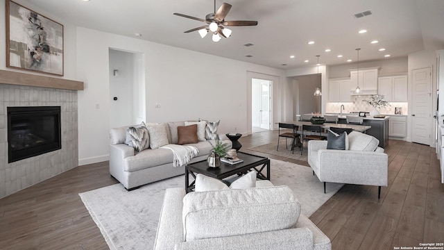 living room with recessed lighting, a fireplace, wood finished floors, a ceiling fan, and visible vents