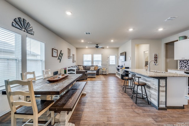 dining room with ceiling fan, wood-type flooring, and sink