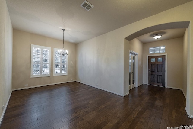 foyer entrance featuring dark hardwood / wood-style floors and an inviting chandelier