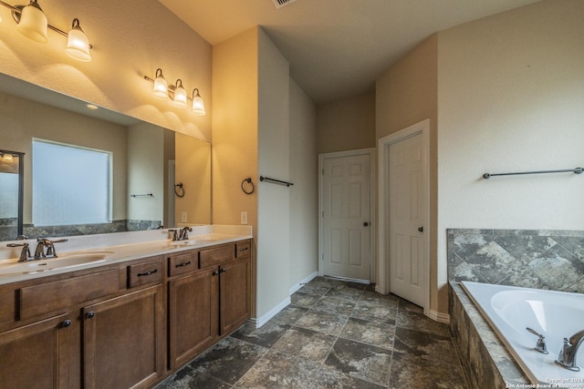 bathroom featuring vanity and tiled bath