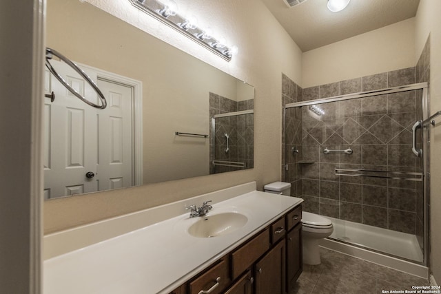 bathroom featuring vanity, tile patterned flooring, toilet, a textured ceiling, and an enclosed shower