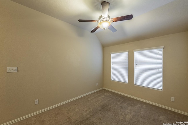 unfurnished room featuring dark colored carpet, vaulted ceiling, and ceiling fan