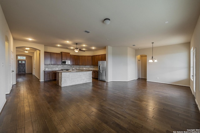 kitchen featuring a center island, dark hardwood / wood-style floors, backsplash, pendant lighting, and appliances with stainless steel finishes