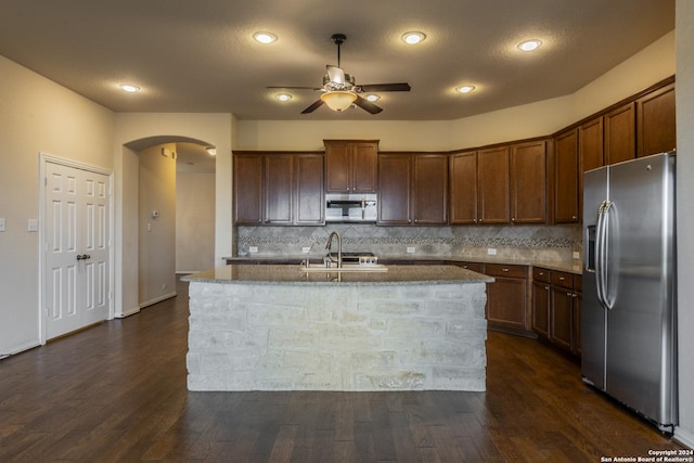 kitchen featuring appliances with stainless steel finishes, dark hardwood / wood-style flooring, and a kitchen island with sink