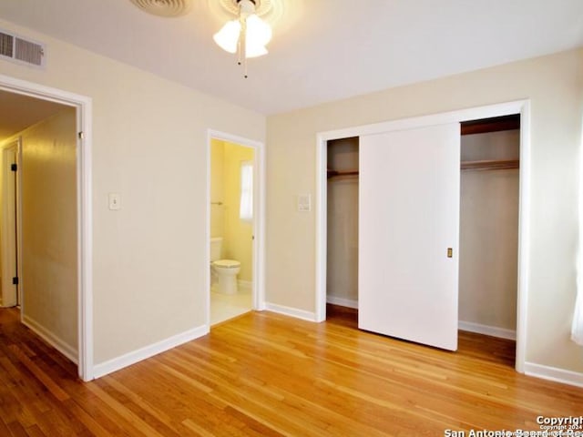 unfurnished bedroom with wood-type flooring, connected bathroom, a closet, and ceiling fan