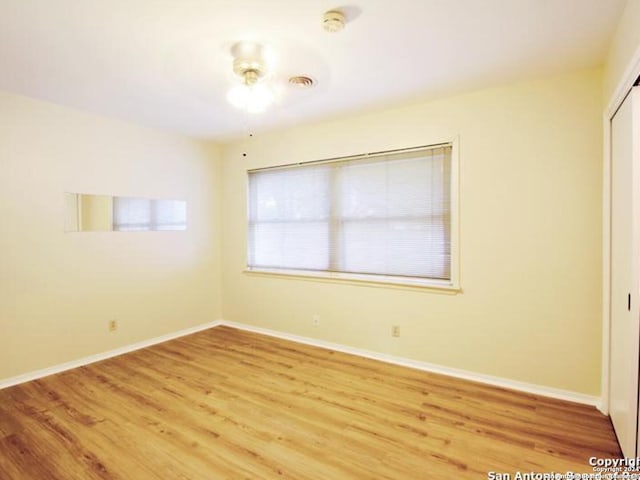 empty room with hardwood / wood-style floors and ceiling fan