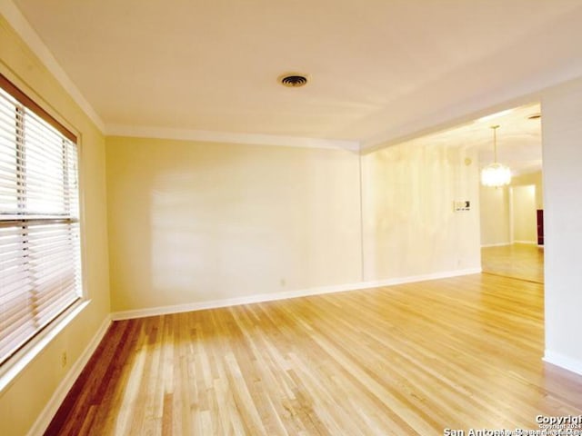 spare room featuring hardwood / wood-style flooring and ornamental molding