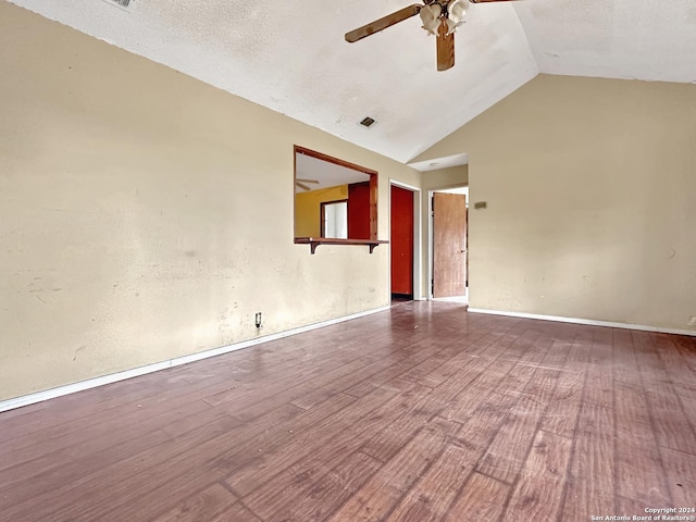 unfurnished room featuring lofted ceiling, ceiling fan, wood-type flooring, and a textured ceiling