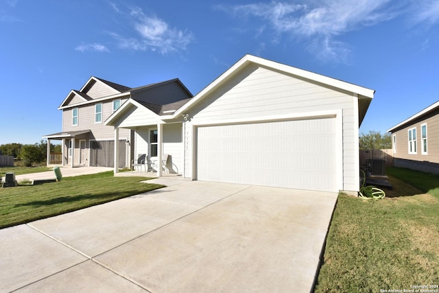 view of front of house with central air condition unit, a front lawn, covered porch, and a garage