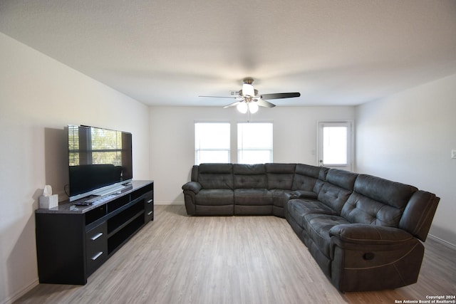 living room with a wealth of natural light, ceiling fan, and light wood-type flooring