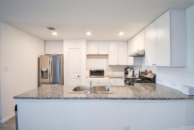 kitchen with sink, dark hardwood / wood-style floors, kitchen peninsula, white cabinets, and appliances with stainless steel finishes