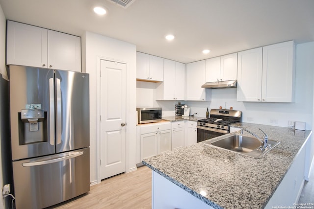 kitchen featuring kitchen peninsula, appliances with stainless steel finishes, white cabinets, and sink