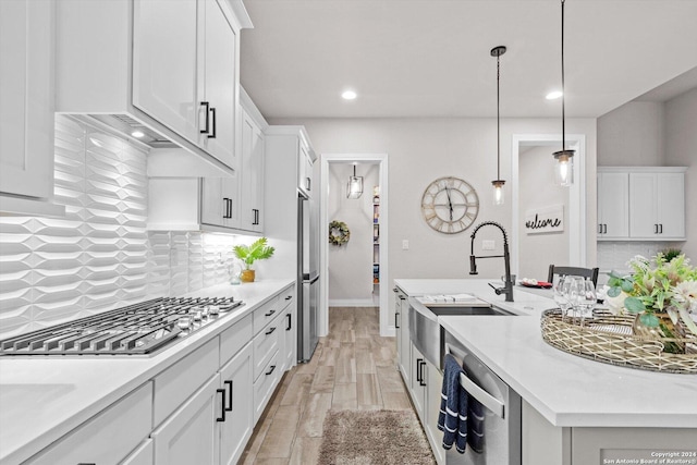 kitchen featuring backsplash, white cabinetry, and stainless steel appliances