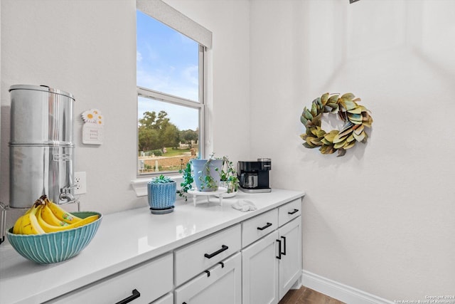 bar featuring white cabinetry and hardwood / wood-style floors