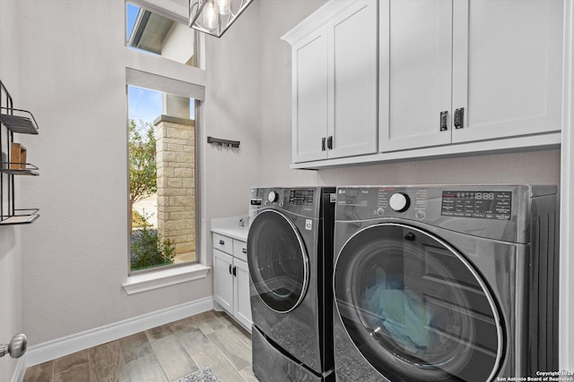 laundry area featuring light hardwood / wood-style floors, cabinets, and washing machine and dryer