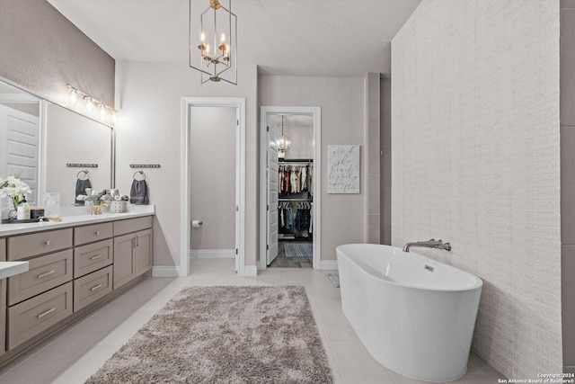 bathroom with a washtub, tile patterned floors, a chandelier, vanity, and tile walls