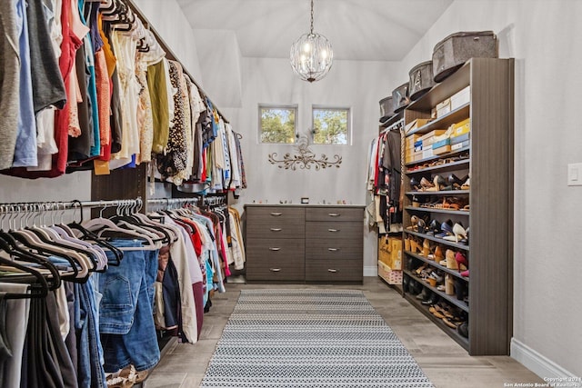 walk in closet featuring a chandelier and light wood-type flooring