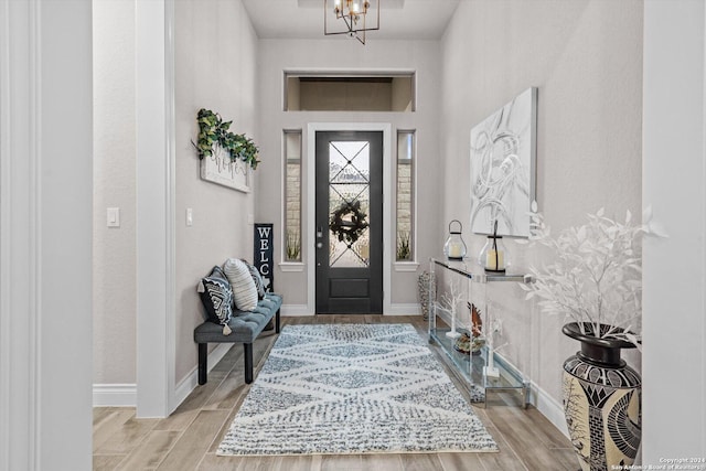 foyer entrance with an inviting chandelier and light hardwood / wood-style flooring