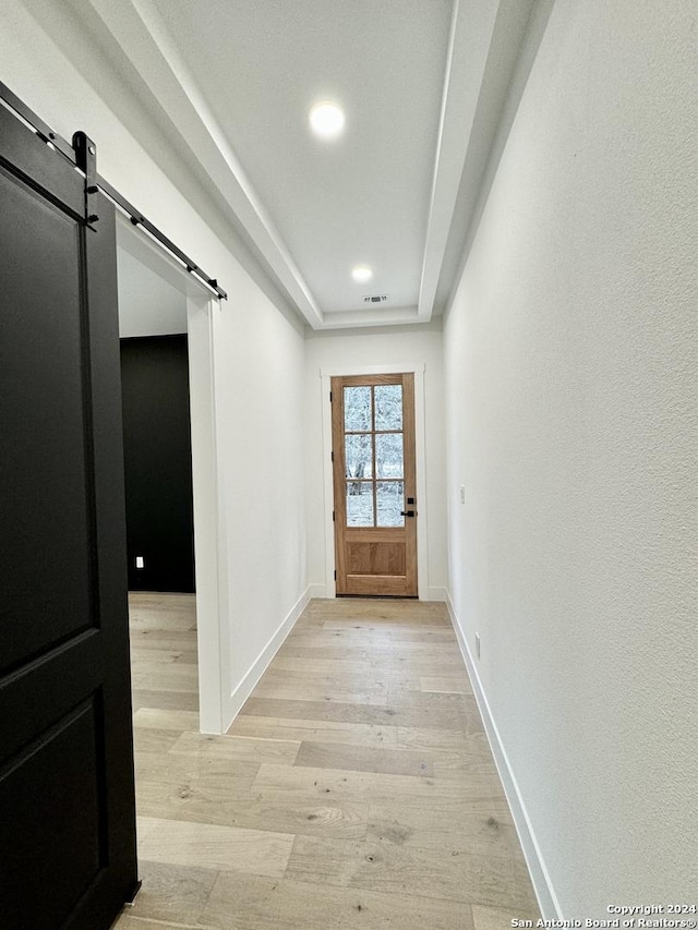 doorway to outside with a barn door and light hardwood / wood-style floors